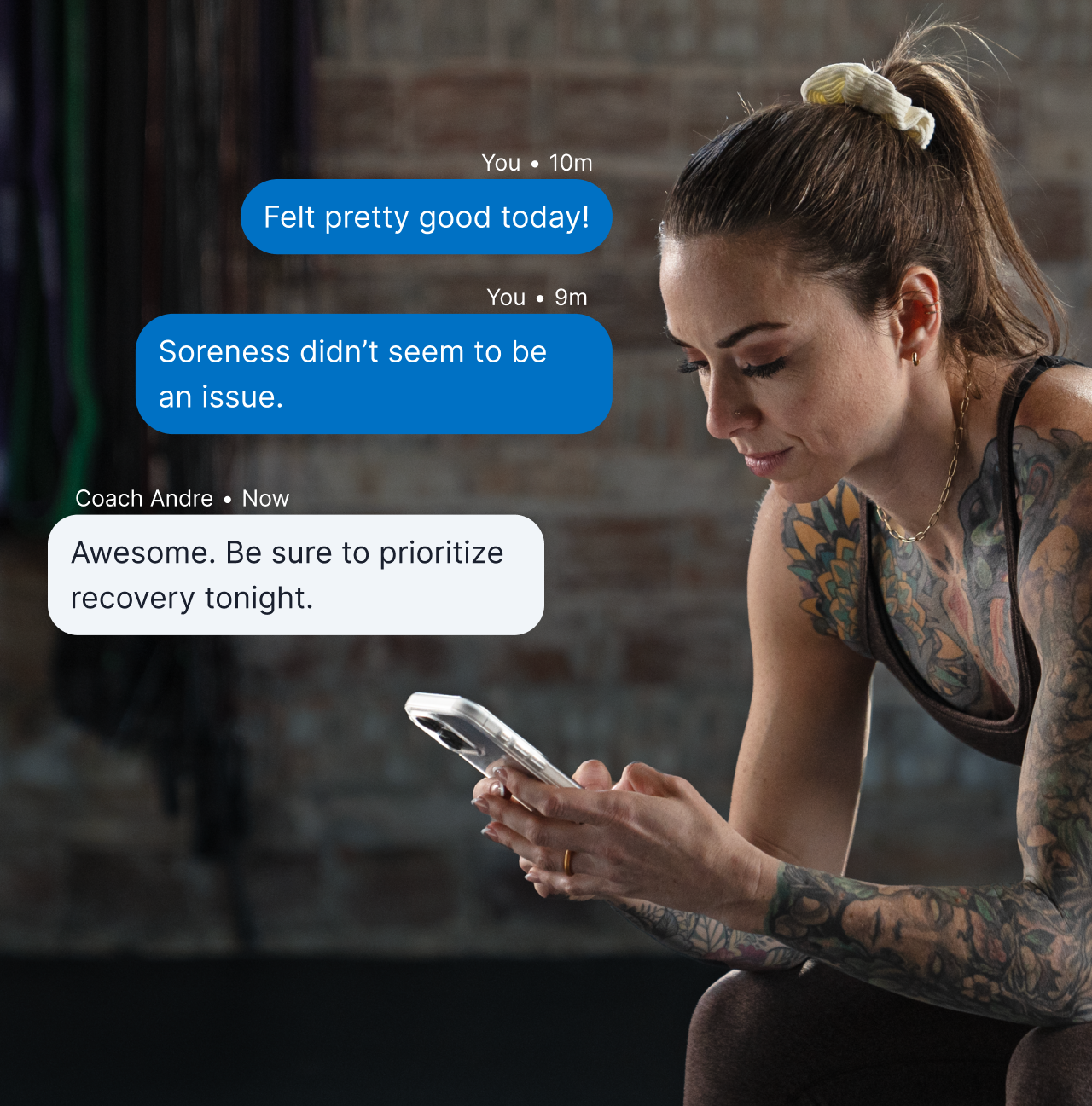 Empowered Results Strength A Woman Athlete Looks At Her Phone In The Gym. On The Image Is A Graphic Overlay Of A Chat Message With The Athlete And Her Coach.